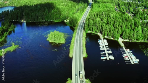 Aerial View of Serene Highway Bordered by Lush Forests and Calm Waterways with Marinas in Finland