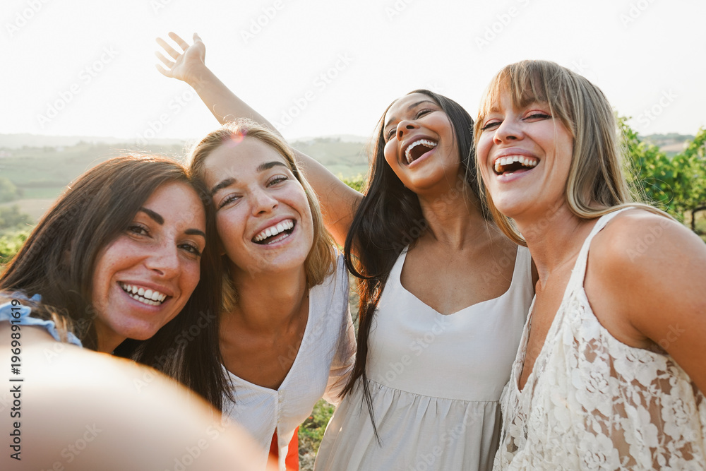 Fototapeta premium Group of female friends having fun at summer event in countryside with vineyards in background - Summer vacation, UGC content, party and travel concept - Main focus on center latin woman face