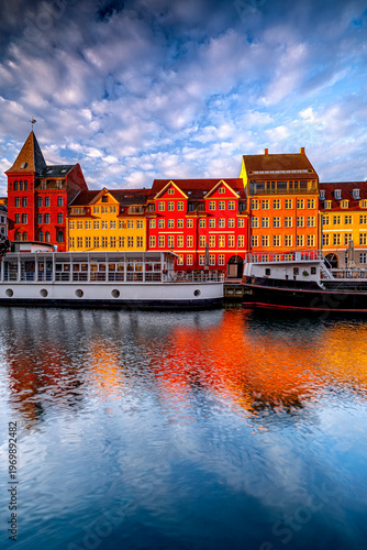 Vertical photo colorful buildings Nyhavn in Copenhagen at sunrise, beautiful illuminated Danish architecture, Scandinavia.