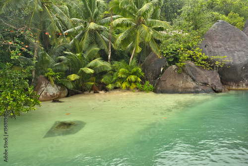 Beautiful small beach with granite stones and white sandy beach at cap ternay, Mahe, Seychelles