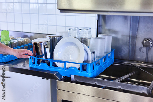 Professionelles Geschirrspülen in einer Großküche oder Kantine.
