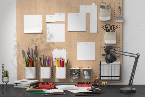 Creative workspace with pegboard organizer, art supplies and mockup papers