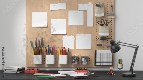 Creative workspace with pegboard organizer, art supplies and mockup papers