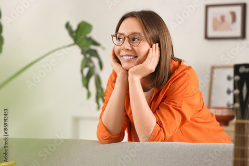 Happy young woman leaning o...