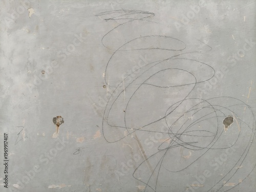 Close-up of a Pale Grey Plaster Wall with Pencil Scribbles and Small Surface Damages