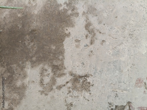 Top View of a Weathered Grey Concrete Floor with Dark Damp Stains and Rough Surface Texture