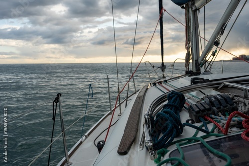 Sailboat deck with ropes against ocean sunset