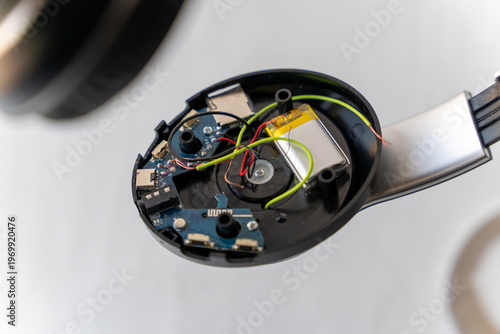Foto Broken headphones show internal parts and wires on a worktable