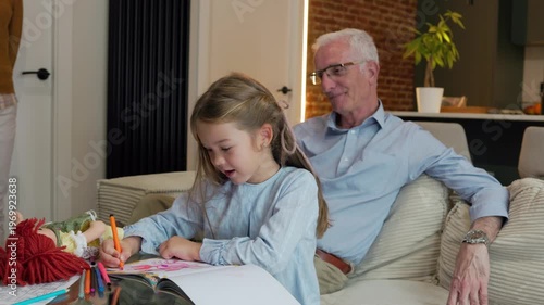 Smiling grandfather giving allowance to granddaughter, teaching her about saving money