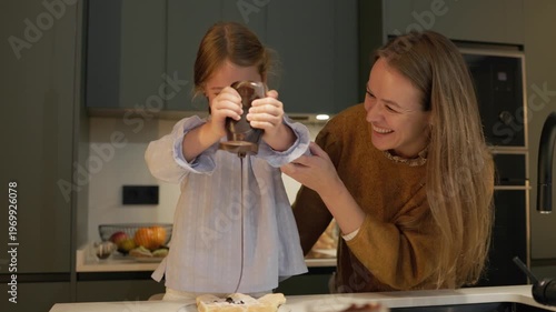 Girl and mother preparing dough, sprinkling flour, making homemade cookies
