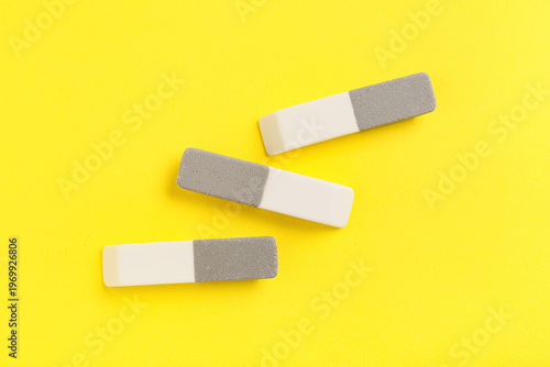Rubber erasers on yellow ba...