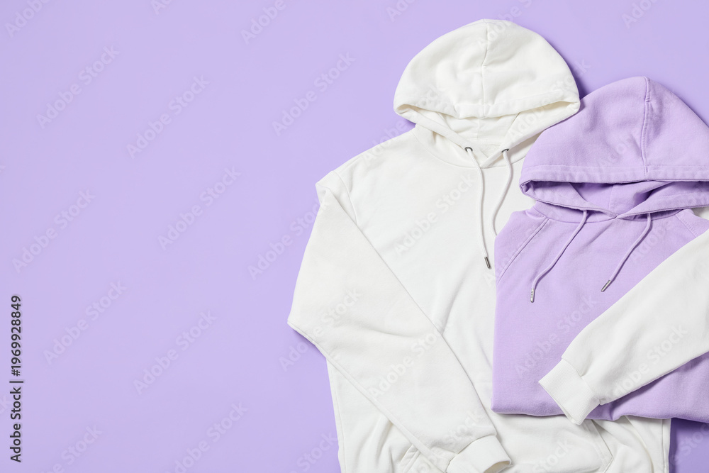 Fototapeta premium Stylish hoodies on lilac background