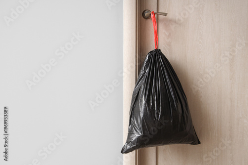 Full garbage bag hanging on...