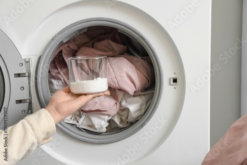 Female hand pouring laundry...