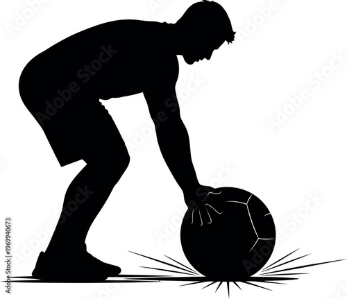 Silhouette of a person picking up a rugby ball on a field
