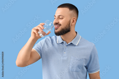 Young man drinking water on...
