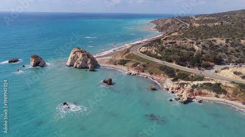 Aerial drone view of Aphrodite's Rock with turquoise sea and nearby coastal road, one of Cyprus' most famous natural landmarks