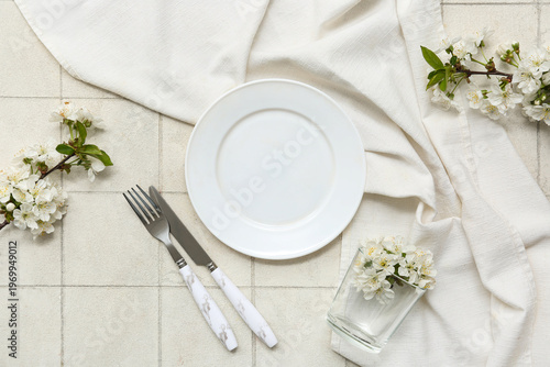 Beautiful table setting with blooming branches on white tile background
