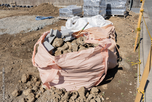 住宅・家の解体後の更地に置かれた石の塊とコンクリートブロック入りのフレコンバッグ