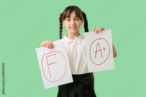 Happy schoolgirl holding pa...