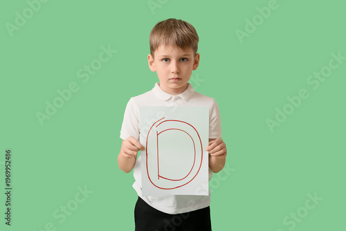 Sad schoolboy holding paper...