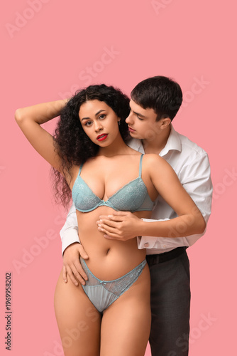 Sexy young couple on pink b...