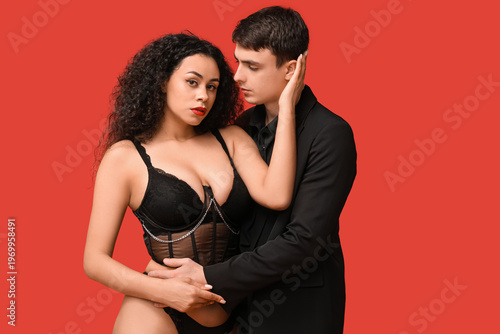Sexy young couple on red ba...