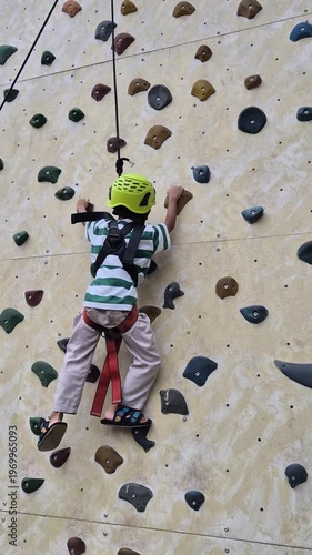 A boy climbing a wall at an outbound arena