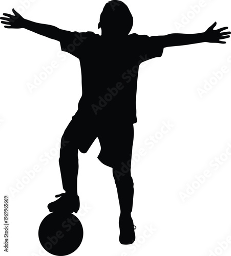 Silhouette of a triumphant child celebrating with a soccer ball and outstretched arms