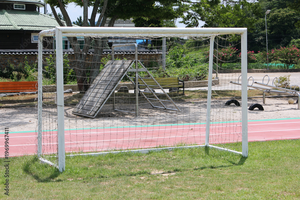 Fototapeta premium Soccer football field near urban school building