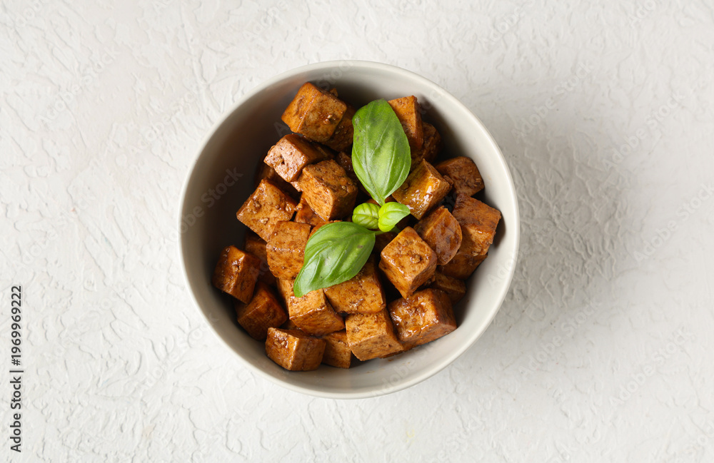 Fototapeta premium Bowl with pieces of fried tofu cheese and basil on white background