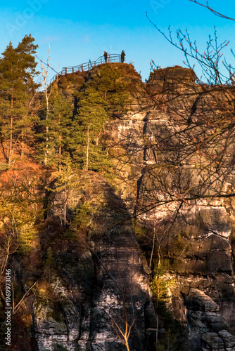 Beautiful close-up of the Ferdinandstein, part of the Wehltürme rock towers and a well-known viewpoint toward the Bastei Bridge, set against a blue winter sky at sunrise.