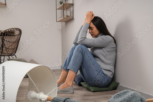 Depressed young woman sitti...