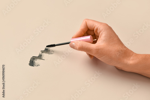 Woman holding black mascara...