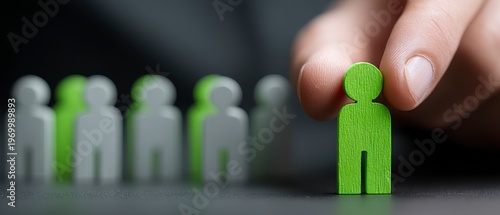 Selecting a Green Textured Humanoid Figure From a Row of White Figures For Recruitment Or Team Building