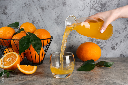 Woman pouring fresh orange ...