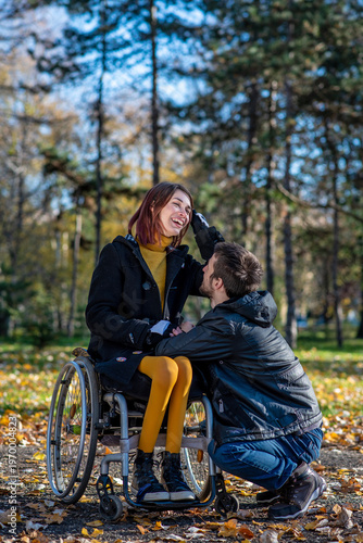 Young woman in a wheelchair with her boyfriend in a park