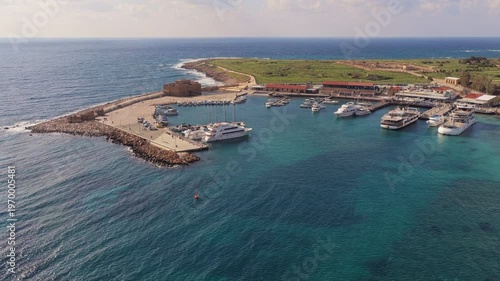 Aerial drone view of marina with yachts and harbor structures along the Cyprus coastline