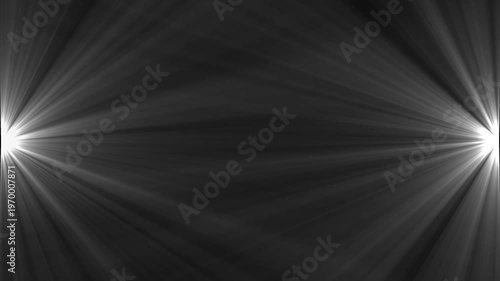 Bright white light rays beaming in dark background starburst light effect closeup abstract lens flare for transitions and overlays in digital media