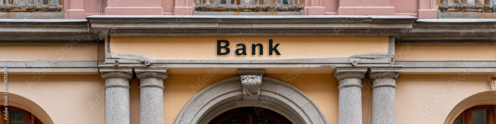 Fototapeta premium Bank pale yellow facade with granite columns arch entrance balcony balustrade classical urban architecture and decorative cornice