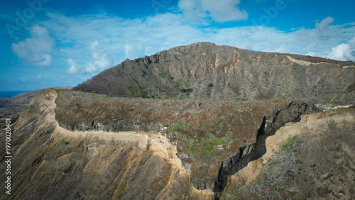 Aerial view of rugged Koko Head volcano crater rim, where the arid, steep slopes meet the vast, blue Pacific horizon, Honolulu, Hawaii, United States.
