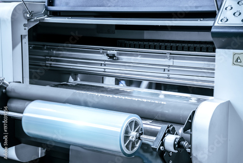 Fotografie Industrial Laminating and rewinding kind of protective film machine with clamping rollers automatic edge banding in a bustling factory setting