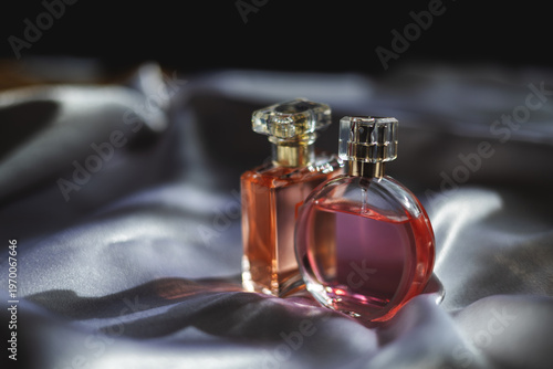 Two luxury women’s perfume bottles on silk fabric, elegant fragrance and beauty concept