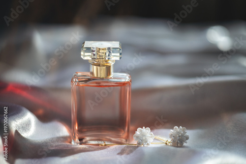 Luxury women’s perfume with elegant earrings on silk background, premium beauty and fashion concept