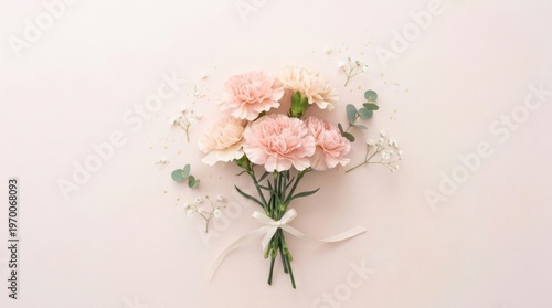 Soft pink carnation bouquet tied with a delicate ribbon on a pastel background