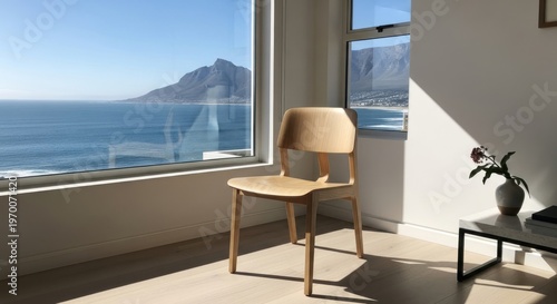 Modern wooden chair in a sunlit room with a scenic ocean view.