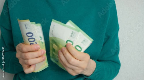 Hands of a woman holding and counting European Union currency.