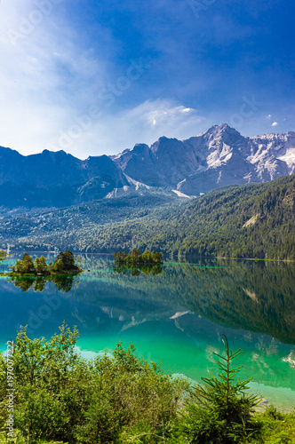Wasserspiegelung in klaren Bergsee Eibsee in Bayern unterhalb der Zugspitze d...