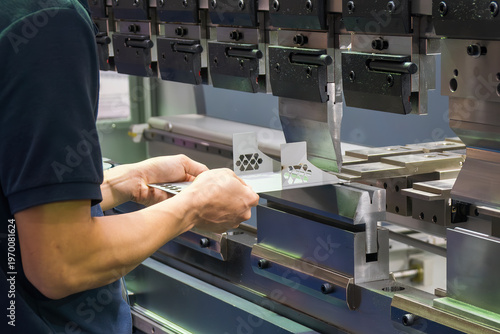 Professional operator performing a precise sheet metal bending process using a heavy-duty hydraulic press brake machine.