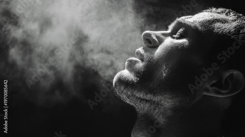 Focused athletic exhale. Male competitor showing concentration during intense physical exertion. Athlete demonstrating resilience and focus through deliberate breathing after vigorous exercise
